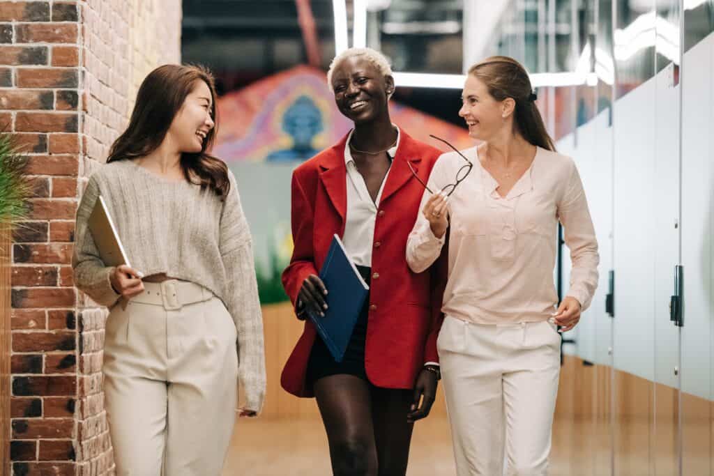 Three businesswomen walking in a modern office